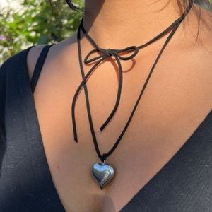 Puffed heart pendant on a long black wrap around cord necklace.
